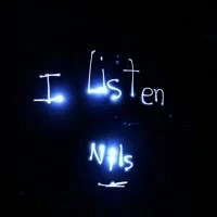 the words i listen nls are written on a dark wall